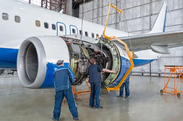 Technicians carrying out aircraft engine maintenance