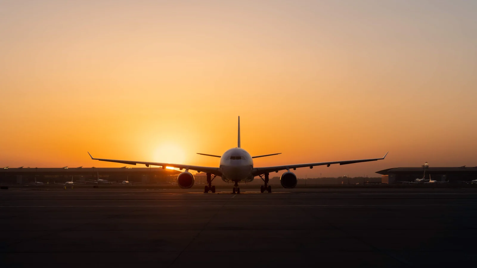 Airliner at the end of a runway at sunset